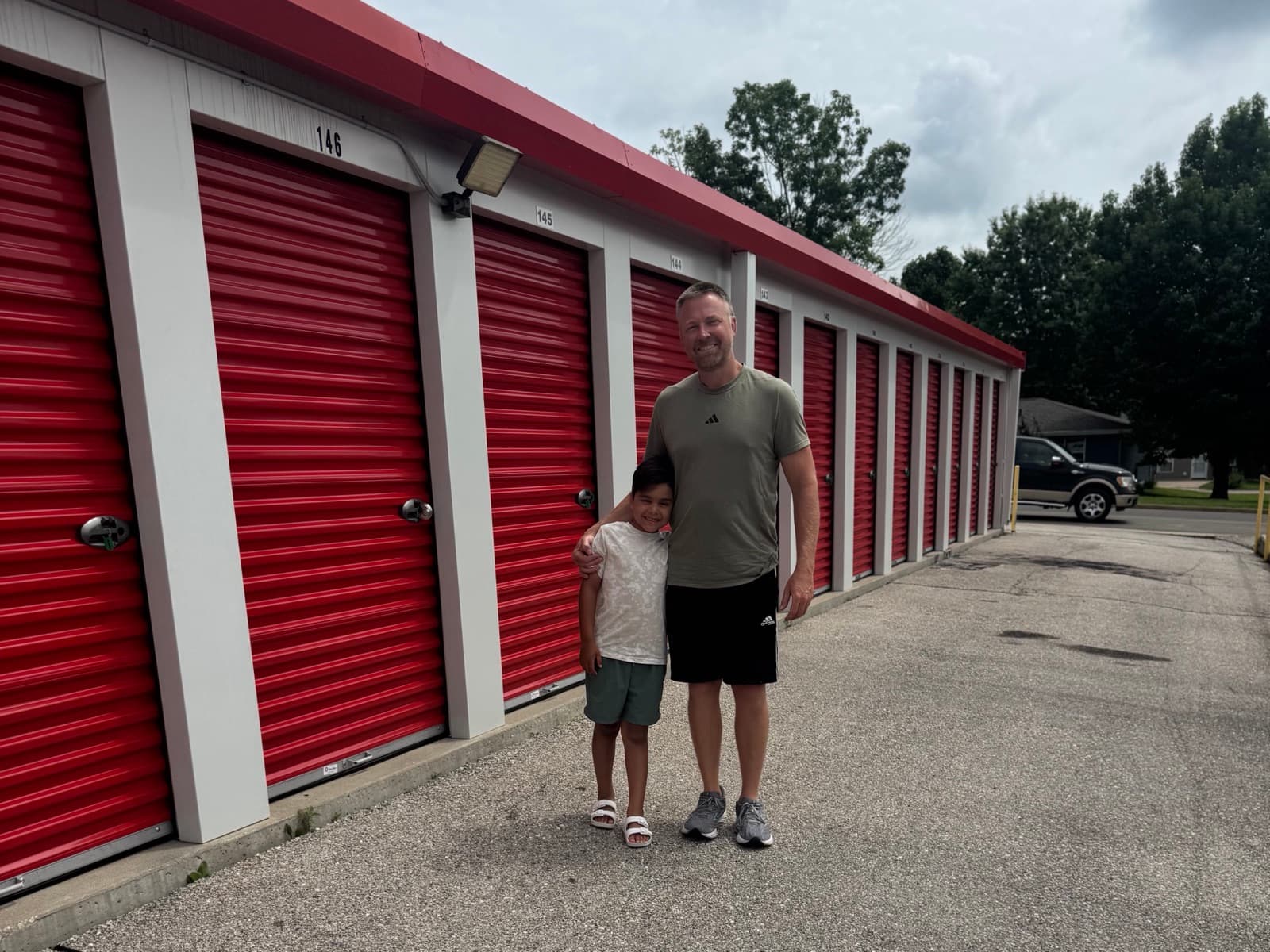 Kenny Buelterman and his son Fisher in front of the red roll-up doors at their Rolla, Missouri storage facility